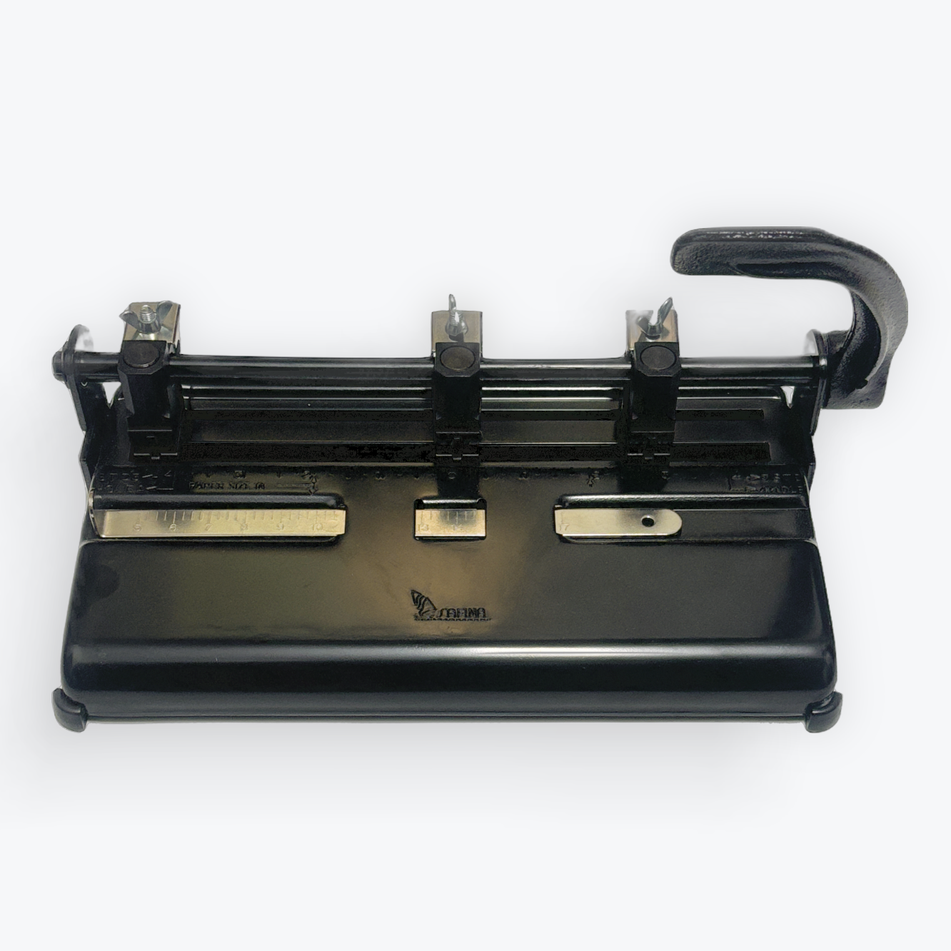 A black industrial paper punch machine with a curved handle, shown from a top-down angle on a light gray background.