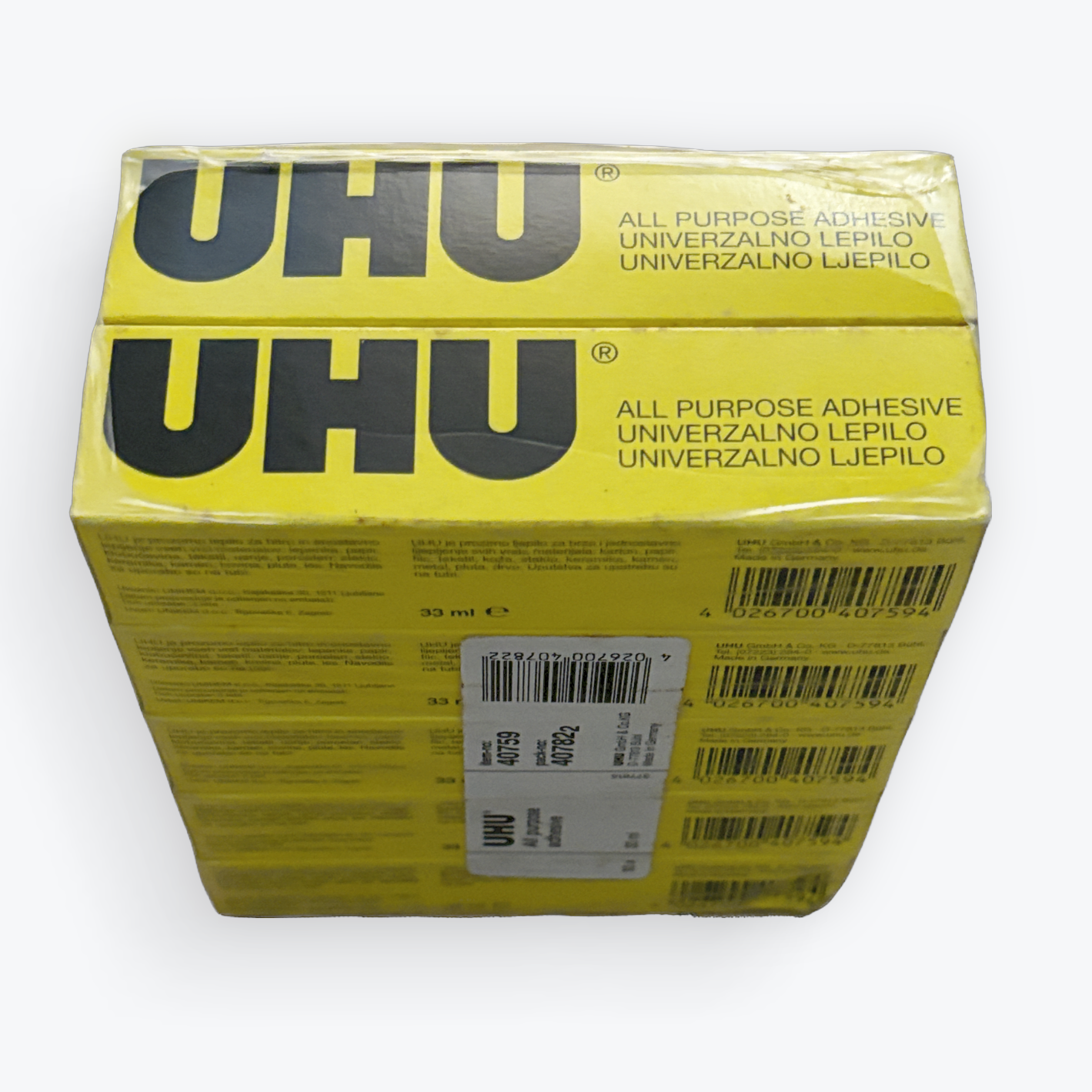 A yellow box of UHU All Purpose Adhesive, shown from an elevated angle against a plain white background.