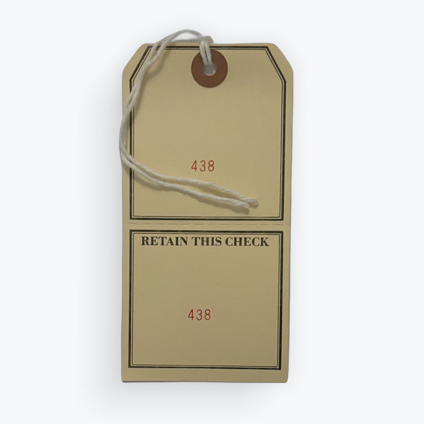 A vintage-style paper check retention tag with a white string loop, featuring the text 'RETAIN THIS CHECK' and the numbers '438' printed in red, shown on a light gray background.