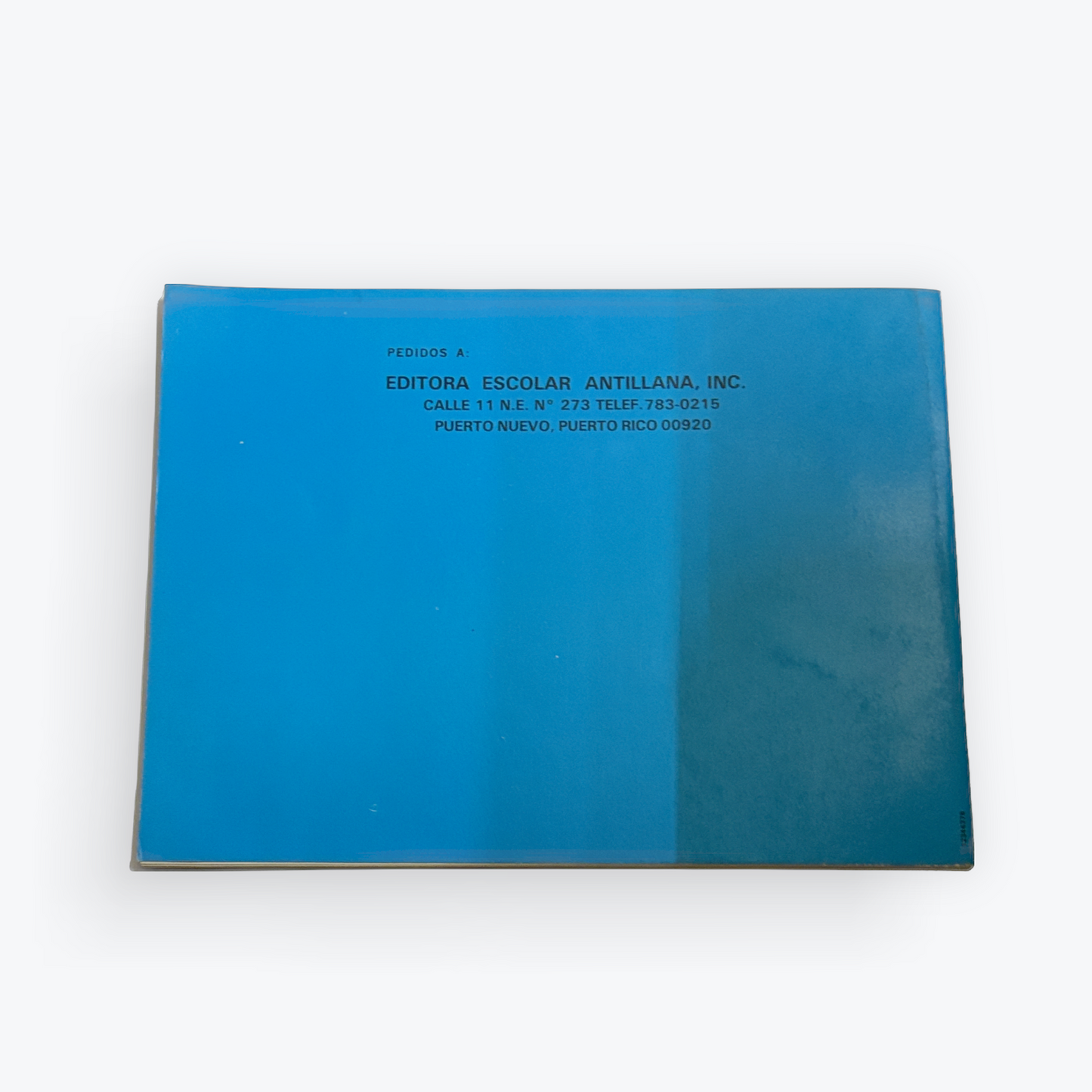 A square blue book or booklet with printed text on the cover, photographed from above on a plain white background.