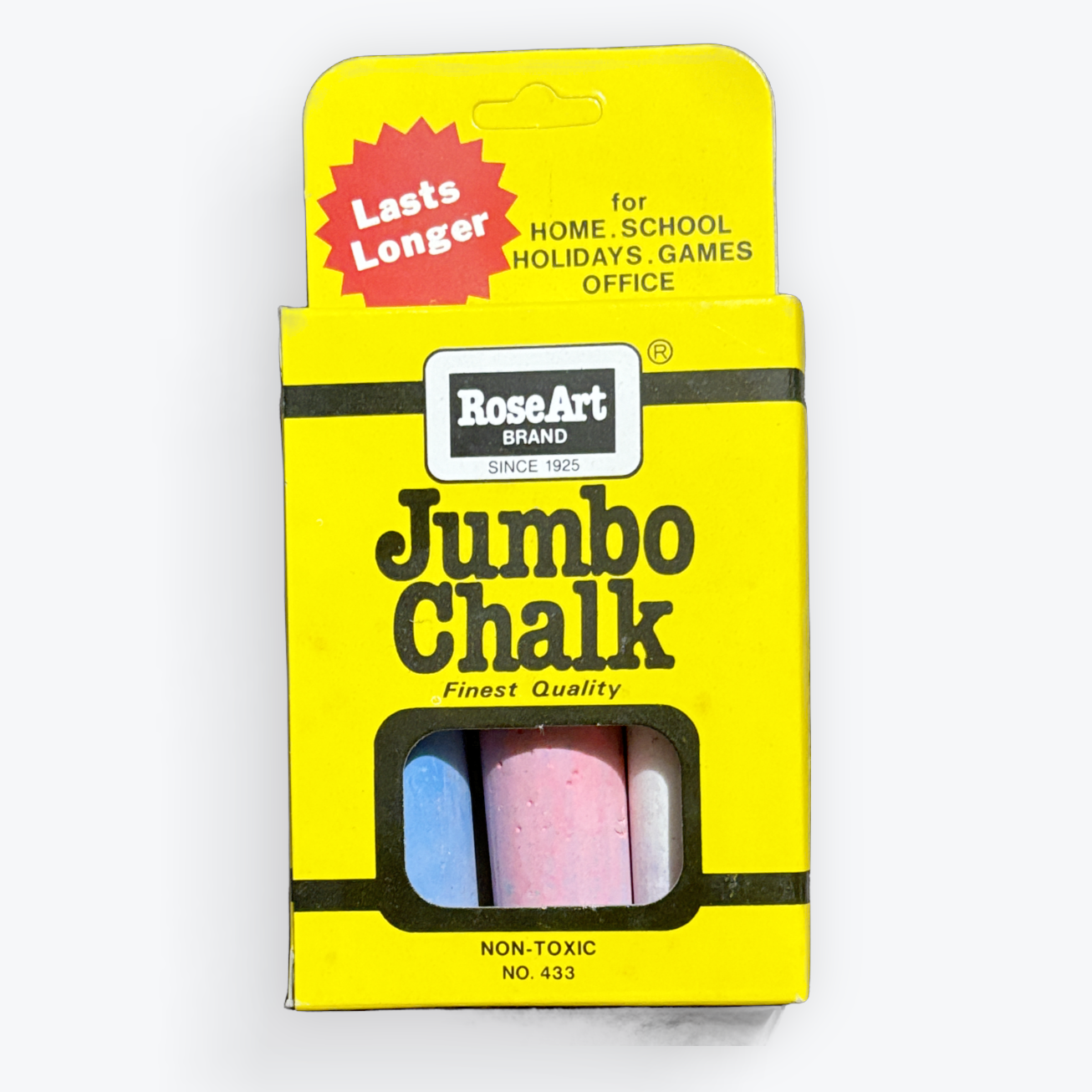 A package of RoseArt Brand Jumbo Chalk containing three pastel-colored chalk sticks (blue, pink, and white) visible through a clear window on a bright yellow cardboard backing, set against a plain white background.