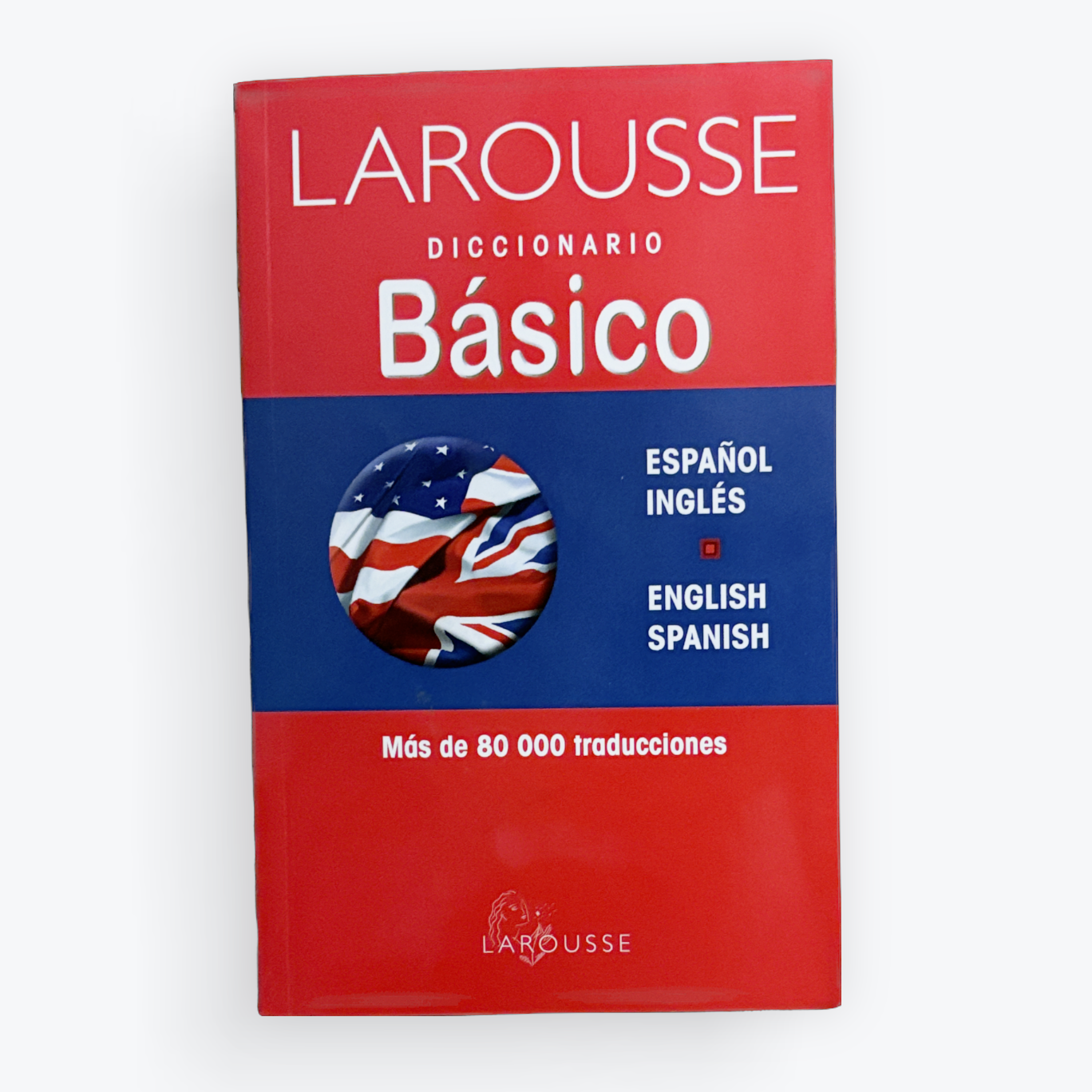 Larousse Diccionario Básico Spanish-English dictionary book cover, featuring a red and blue design with a circular American flag and English flag graphic, set against a plain white background.