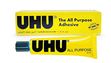 A yellow tube of UHU All Purpose Adhesive with a black cap, shown in front of its matching yellow packaging box on a plain white background.
