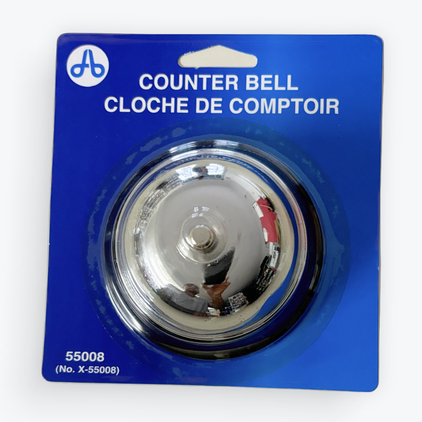 A silver chrome counter bell in its original blue blister packaging, labeled 'COUNTER BELL CLOCHE DE COMPTOIR' with a white logo at the top left.